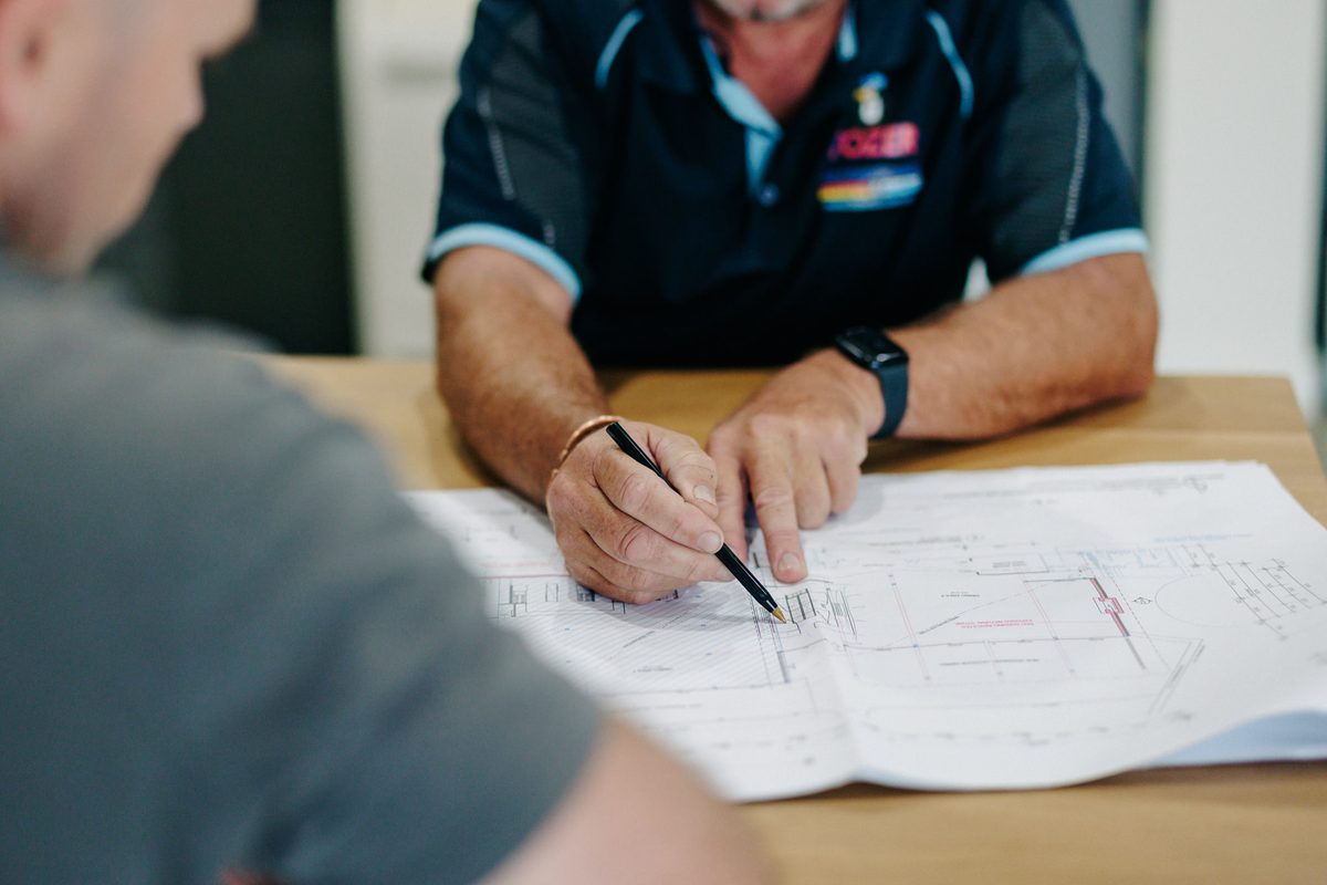 A Tozer Air specialist going through a quote with a homeowner at their kitchen table